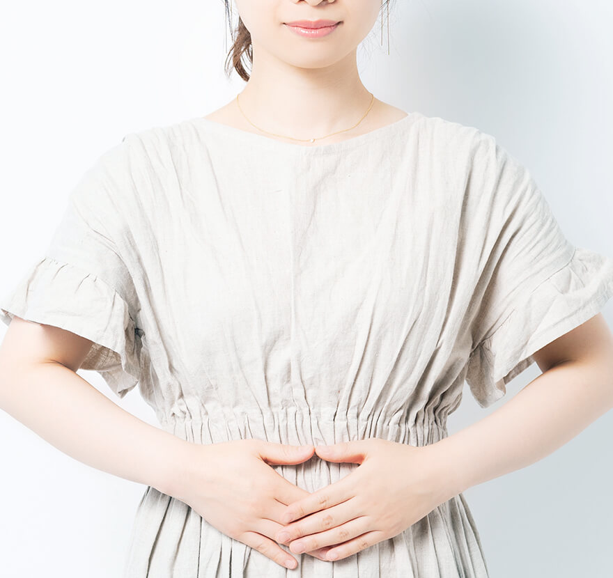 お腹に手を当てる女性